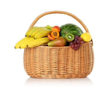 Hasır sepetteki birçok farklı taze meyve beyaza izole edilmiş.