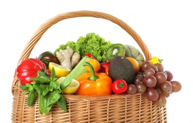 Hasır sepetin içindeki birçok farklı meyve ve sebze beyaza izole edilmiş.