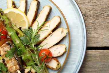 Lezzetli ızgara sebzeler ve ahşap masada tavuk eti.