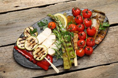 Lezzetli ızgara sebzeler ve ahşap masada tavuk eti.