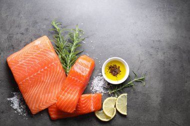 Taze somon, limon ve baharat parçaları gri masada, düz yerde. Metin için boşluk
