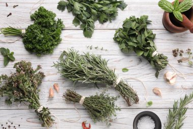 Beyaz ahşap masa üzerinde farklı aromatik otlar, düz yatıyordu.