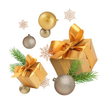 Hediye kutuları, Noel baloları, köknar ağacı dalları ve beyaz arka planda süslü kar taneleri.