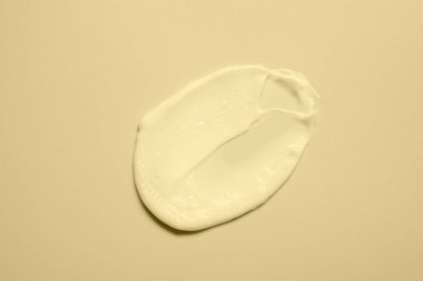 Bej arka planda yüz kremi örneği, üst görünüm