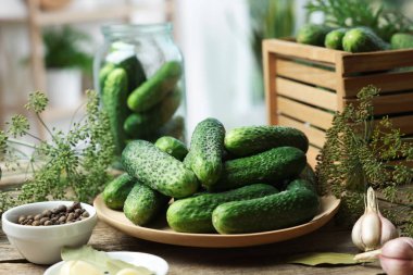 Taze salatalıklar, ahşap masada dereotu ve baharatlar, yakın plan. Turşu hazırlama