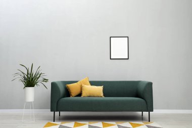 Rahat kanepe ve bitki örtüsü olan şık bir oda.