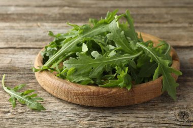 Taze yeşil roka yaprakları ahşap masada, yakın plan.