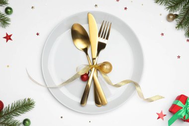 Tabak, çatal bıçak takımı ve beyaz arka planda şenlikli Noel sofrası, düz yatış