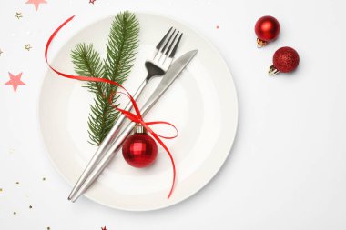 Tabak, çatal bıçak takımı ve beyaz arka planda şenlikli Noel sofrası, düz yatış