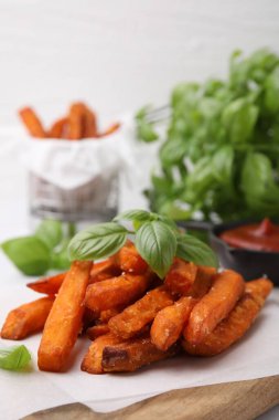 Tatlı patates kızartması ve fesleğen masada, yakın plan.