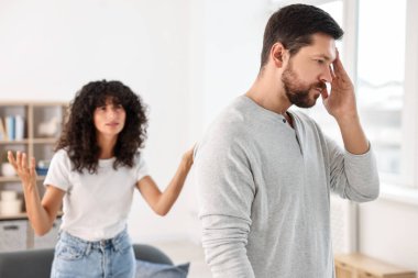 Evde tartışan duygusal bir çift, seçici bir odak noktası. İlişki sorunları