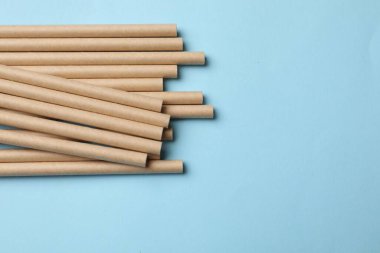 Açık mavi arka planda bambu pipetleri, üst manzara. Metin için boşluk