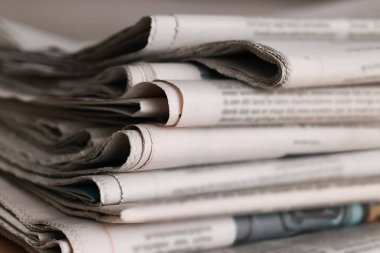 Arka plan olarak farklı dillerde birçok gazete, yakın plan