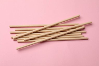 Pembe arka planda bambu pipetleri, üst görünüm