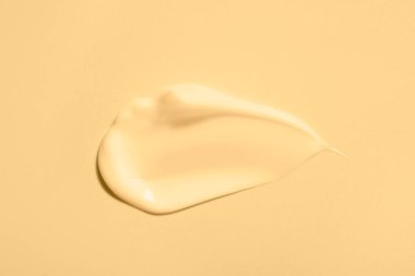 Bej arka planda yüz kremi örneği, üst görünüm