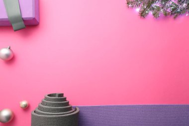 Yoga paspası, blok, köknar dalları ve pembe arka planda Noel dekoru, düz bir yatak. Metin için boşluk