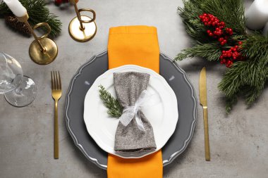 Christmas place setting with festive decor on grey table, flat lay clipart