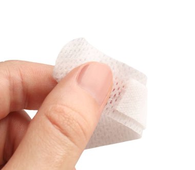 Kadın, beyaz arka plana tıbbi yapıştırıcı bandaj yapıştırıyor. Yakın plan.