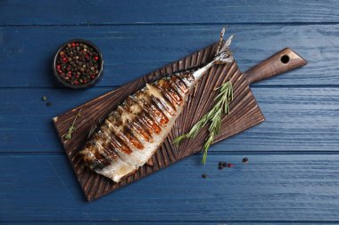 Lezzetli ızgara uskumru, biber ve biberiye ile ahşap masa, düz yatıyordu.