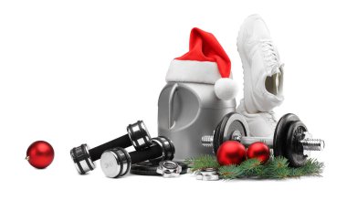 Dambıllar, takviyeli konteynırlar, spor ayakkabılar ve beyaz üzerine izole edilmiş Noel dekoru.