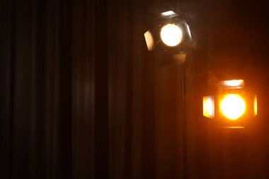 Karanlıkta perdeye karşı profesyonel spot ışıkları. Metin için boşluk