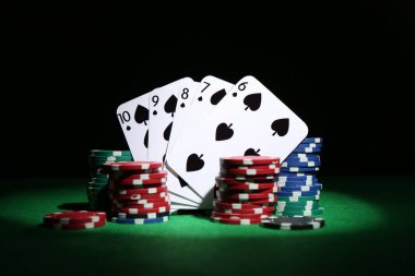 Poker fişleri ve yeşil masada iskambil kartları