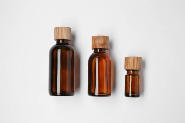 Beyaz arka planda gerekli yağlardan oluşan şişeler, düz bir zemin