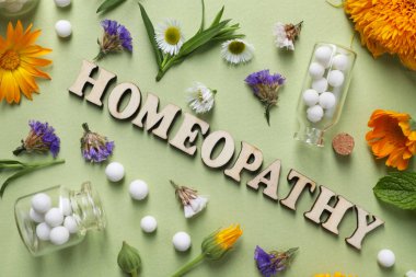 Kelime Homeopati, haplar ve zeytin arka planında şifalı bitkiler, düz uzanma