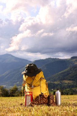 Sırt çantası, yürüyüş ayakkabıları ve diğer kamp ekipmanları çimlerin üzerinde, mesaj için yer