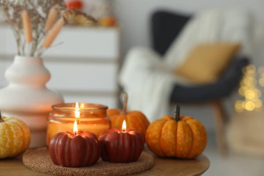 İçerideki ahşap masada mum ve balkabağı yakmak, yazı yazmak için yer açmak. Sonbahar atmosferi