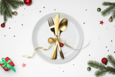 Tabak, çatal bıçak takımı ve beyaz arka planda şenlikli Noel sofrası, düz yatış