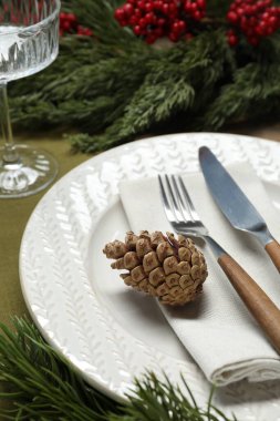 Tabak, çatal bıçak, cam ve şenlik dekorlarıyla Noel sofrası, yakın plan.