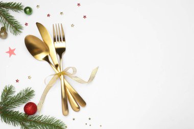Beyaz arka planda tabak, çatal bıçak takımı ve şenlik dekoruyla Noel sofrası. Metin için boşluk
