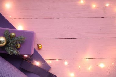 Yoga minderli düz konum ve pembe ahşap arka planda Noel dekoru, metin için boşluk
