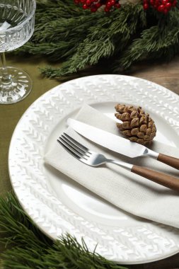 Masada tabak, çatal bıçak, cam ve şenlik dekorlarıyla Noel sofrası