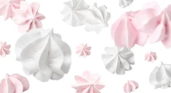 stock image Delicious meringue cookies in air on white background