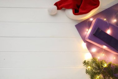 Beyaz ahşap arka planda yoga minderi ve Noel dekoru olan düz bir kompozisyon, metin için boşluk