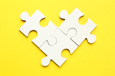 Sarı arkaplanda beyaz yapboz parçaları, üst görünüm