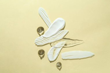 Bej arka planda farklı kozmetik ürünlerinin kokusu, üst görünüm