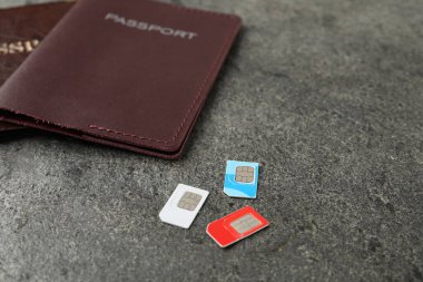 Gri desenli masadaki pasaportlar ve SIM kartlar, yakın plan