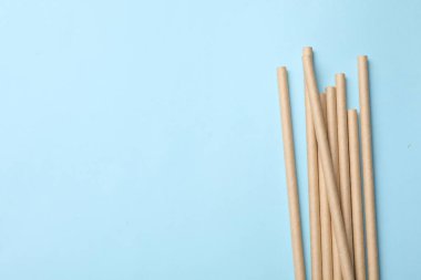 Açık mavi arka planda bambu pipetleri, üst manzara. Metin için boşluk