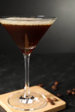 Lezzetli espresso martini ve kahve çekirdekleri ile koyu masa, yakın plan.