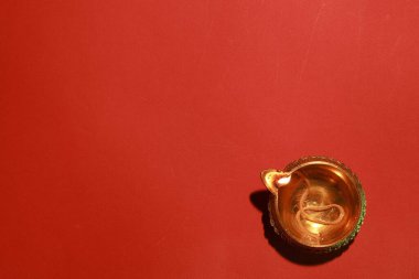 Diwali kutlaması. Kırmızı arkaplanda Diya lambası, üst görünümde. Metin için boşluk
