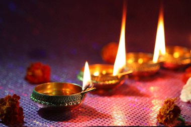 Diwali kutlaması. Diya lambaları ve arkaplanda güzel çiçekler, yakın plan