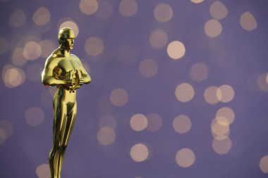 Mor arkaplan üzerine Altın Oscar ödülü bulanık ışıklarla, metin için boşluk