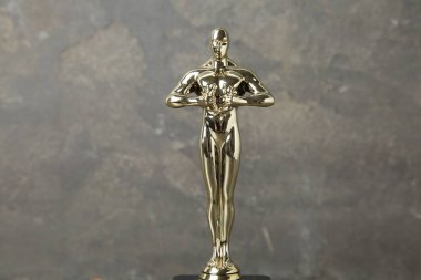 Bulanık gri arka plana karşı Altın Oscar ödülü