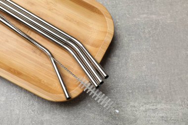 Metal pipetler ve gri desenli masa üzerindeki temizlik fırçası, üst manzara. Metin için boşluk