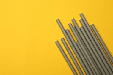 Sarı arka planda bambu pipetleri, üst manzara. Metin için boşluk
