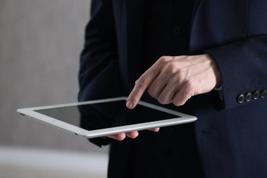 Kapalı alanda tablet kullanan bir iş adamı, yakın plan. Modern teknoloji