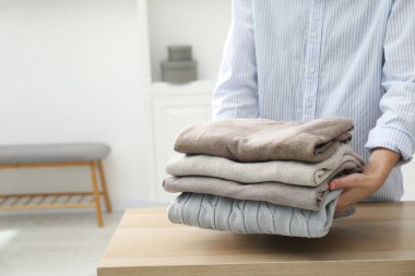 Ahşap masadaki temiz elbiseli kadın, yakın plan.